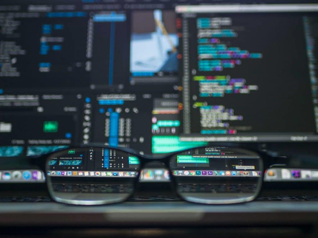 A set of eyeglasses sits in front of a monitor that is displaying marketing automation software.