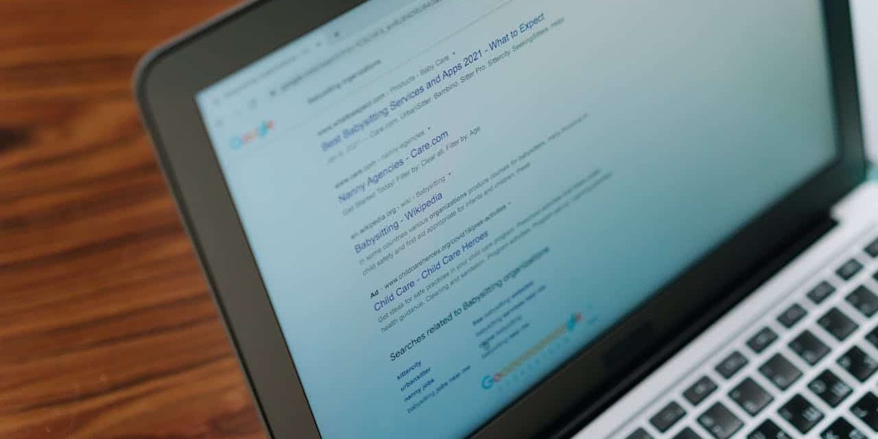 An open laptop, displaying Google search results for lawn care and landscaping companies.