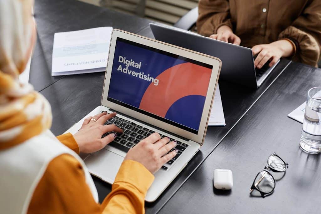 Two people working on digital advertising for green industries on their laptops